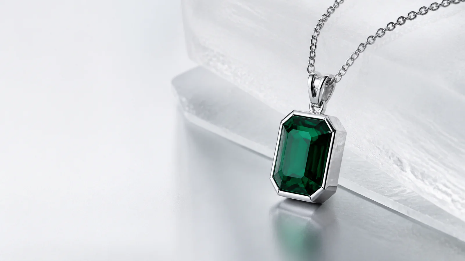 Emerald-cut pendant concept on light stone — originals visual direction