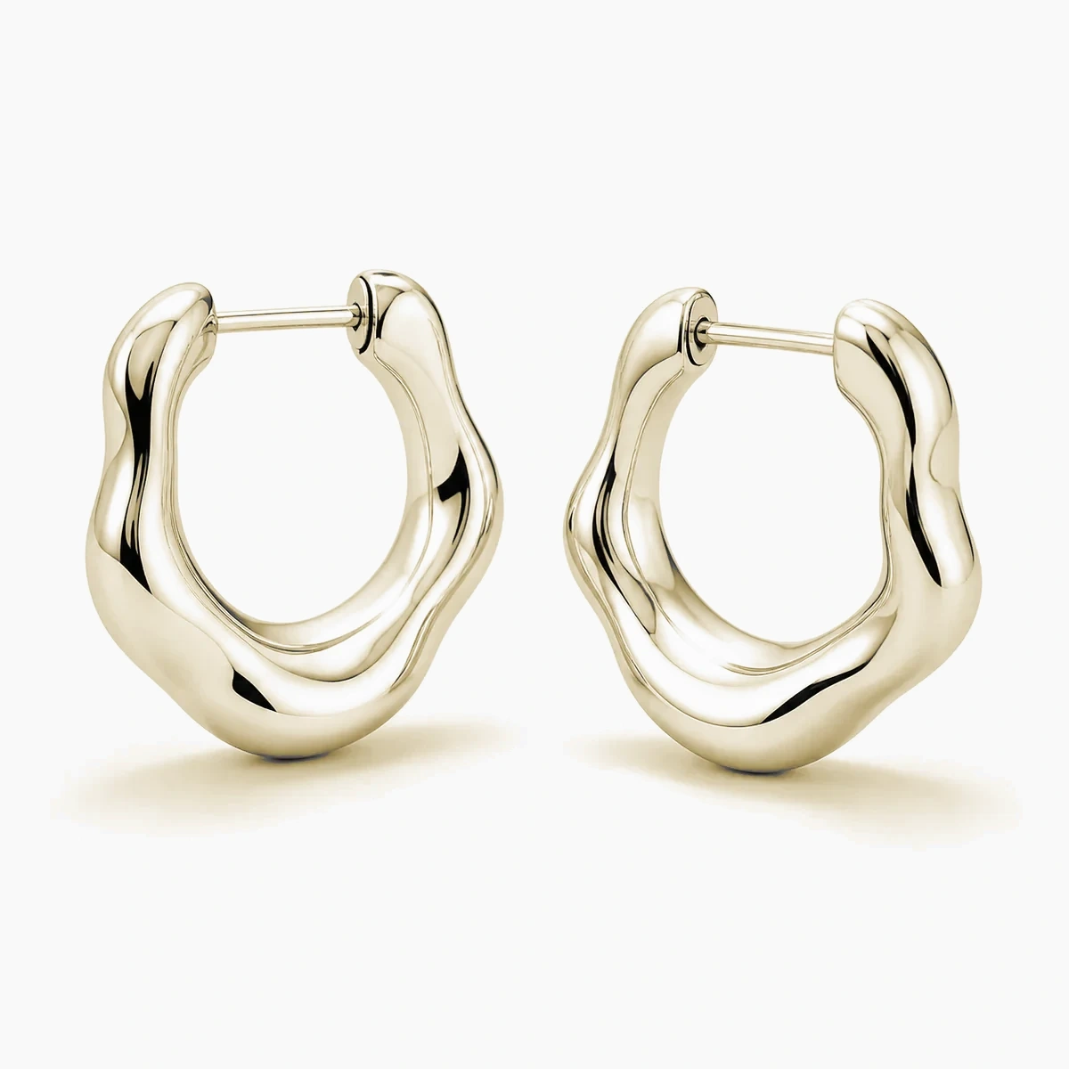 Close study of a sculptural gold-tone hoop — concept material imagery